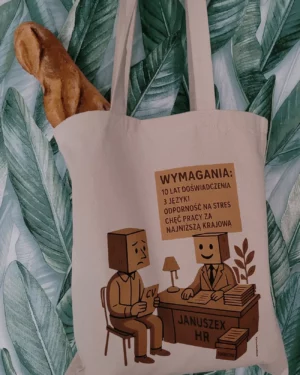 Torba bawełniana Kartonlandii z grafiką Januszex HR i napisem Wymagania: 10 lat doświadczenia, 3 języki, odporność na stres, chęć pracy za najniższą krajową