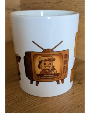 Biały kubek ceramiczny Kartonlandii z grafiką telewizora i napisem Jest dobrze. A będzie jeszcze lepiej